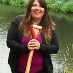 Brenda standing streamside with a shovel