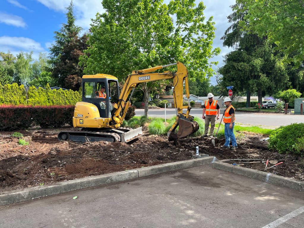 City of Keizer using an excavator to dig out a catch basin.