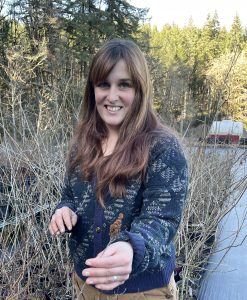 Rachel holds up a plant a the nursery